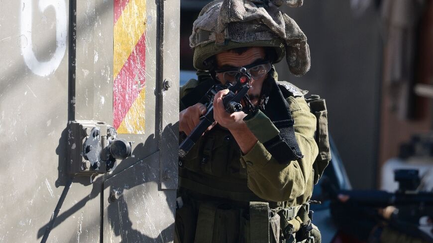 An Israeli soldier takes aim outside the Turkish hospital in Tubas in the occupied West Bank