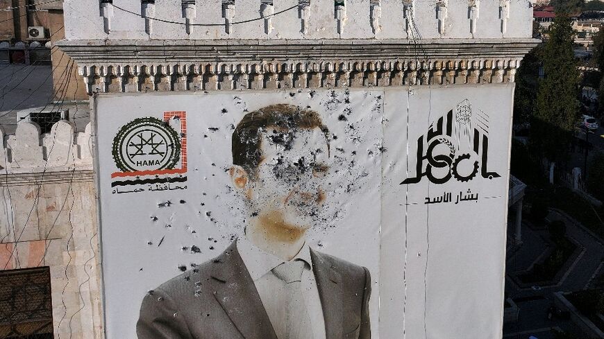 Rebel bullets riddle a portrait of Syrian President Bashar al-Assad on the facade of city hall in Hama.