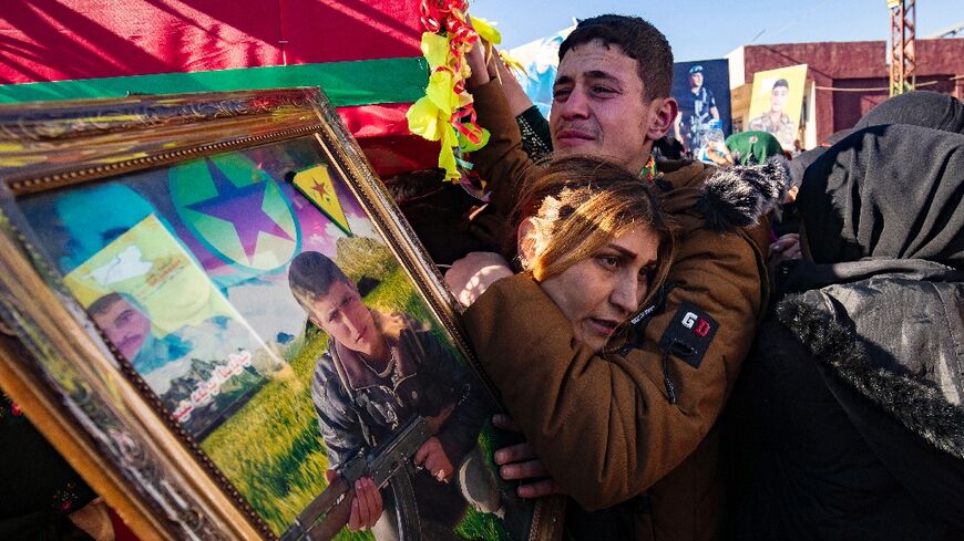 A relative holds a portrait of one of five fighters of the Kurdish-led Syrian Democratic Forces who were killed in clashes with Turkish-backed fighters in the town of Manbij earlier this week.