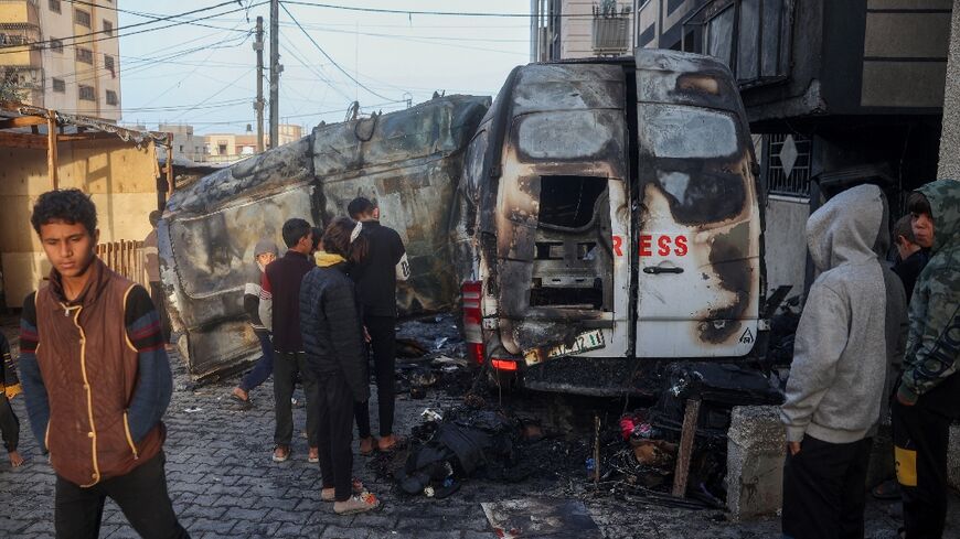 Children check the site of an Israeli strike on a broadcast truck in the Nuseirat refugee camp in the central Gaza Strip, on December 26, 2024