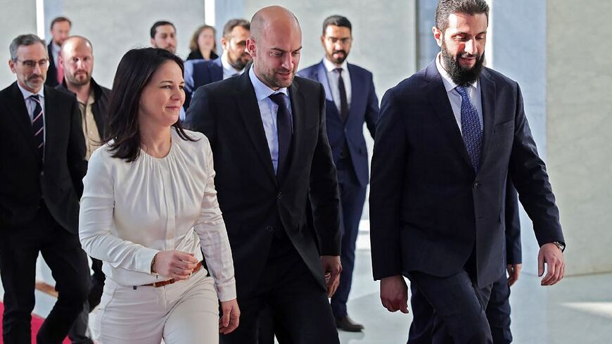 German Foreign Minister Annalena Baerbock (R) and her French counterpart Jean-Noel Barrot (C) walk with Syria's new ruler Ahmed al-Sharaa ahead of their talks in Damascus.