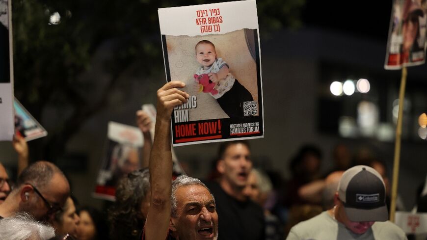 A man raises a portrait of Kfir Bibas at a rally last year calling for the release of hostages held in Gaza