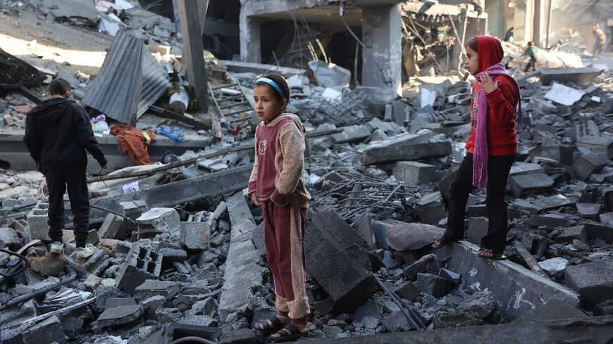 Palestinian children inspect damage after an Israeli strike in Jabalia, in the north of Gaza where several displaced Gazans said they also fear falling temperatures and heavy rains