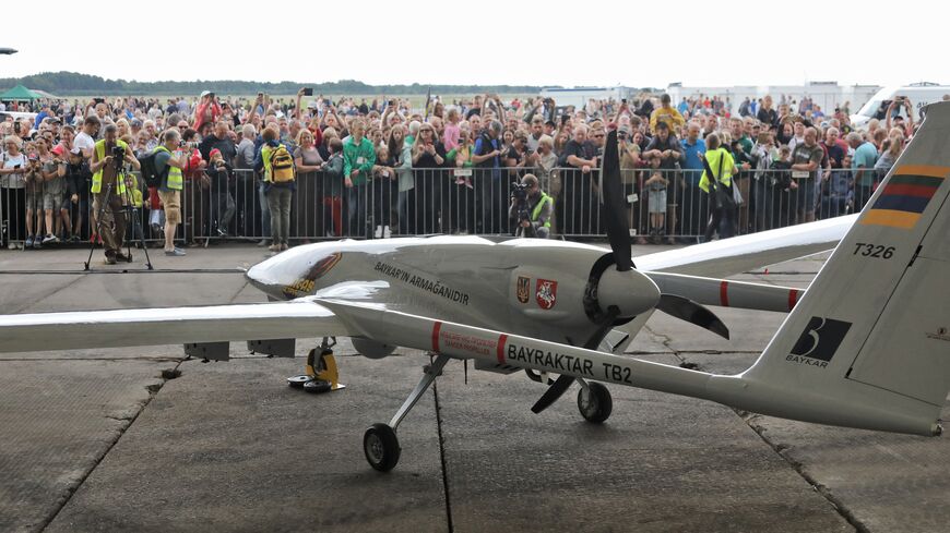 A Turkish Bayraktar TB2 combat drone is on view during a presentation at the Lithuanian Air Force Base in Siauliai, Lithuania, on July 6, 2022. - Lithuania on July 6, 2022 exhibited a crowdfunded Turkish-made military drone that it plans to send to Ukraine to help the war-torn country fight Russia's invasion. People in the NATO member country raised 5.9 million euros for the Bayraktar TB2 drone over three days last month, before its Turkish manufacturer Baykar announced it would donate the drone free of cha