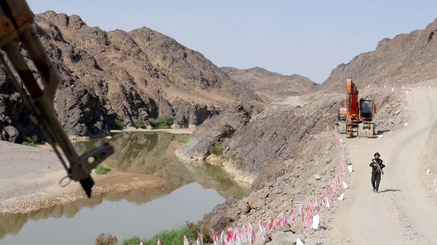 A Taliban security personnel walks along the roadside during the inauguration ceremony of Bakhshabad Dam in Bala Buluk district of Farah province on May 20, 2023. 