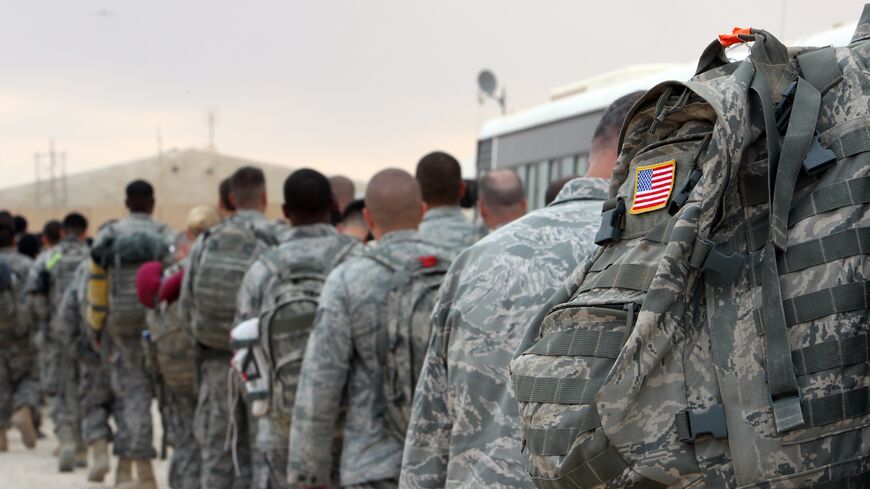 US army soldiers queue to board a plane to begin their journey home out of Iraq from the Ain al-Asad Air Base west of the capital, Baghdad, on Nov. 1, 2011. 