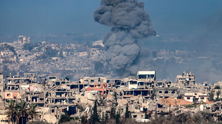 Smoke plume rising from explosions above destroyed buildings in the northern Gaza Strip on January 13, 2025 amid the ongoing war between Israel and Hamas. (Photo by Menahem KAHANA / AFP) (Photo by MENAHEM KAHANA/AFP via Getty Images)