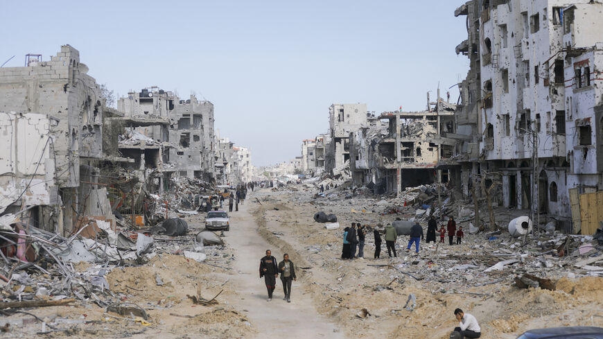 Residents walk through the rubble in the streets, in Al-Balad, Rafah, on January 20, 2025. 