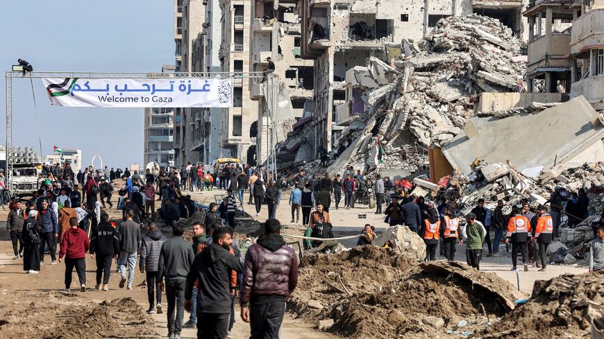 People walk near the rubble of a collapsed building along Gaza's coastal al-Rashid Street, crossing from southern Gaza into Gaza City, Jan. 26, 2025.