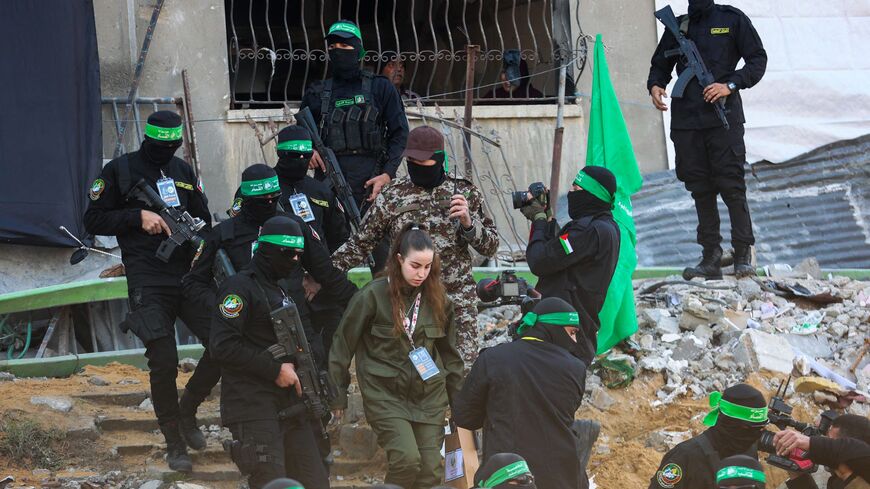 Hamas militants escort Isreali hostage Agam Berger (C) before handing her over to a Red Cross team in Jabalia on January 30, 2025