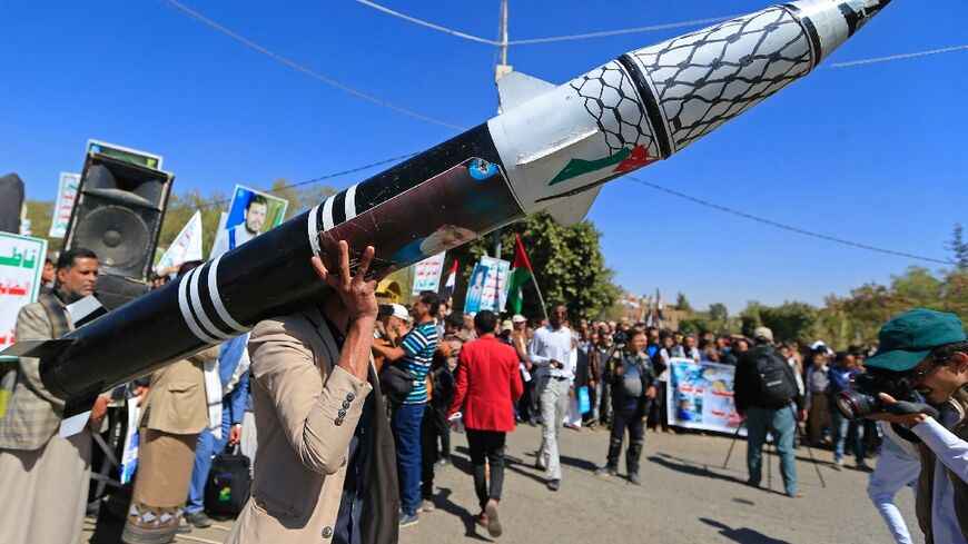 A Yemeni protester holds a mock rocket during an anti-Israel demonstration in the Huthi-controlled capital Sanaa