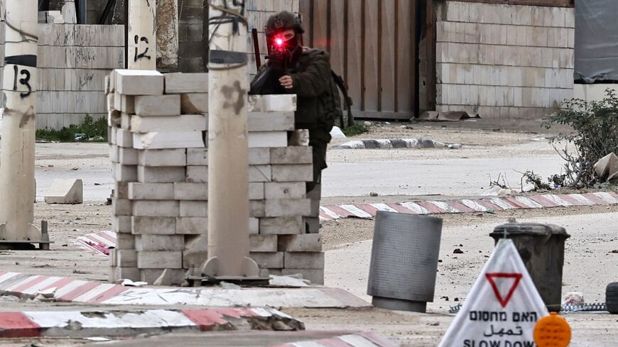 An Israeli soldier takes aim from a checkpoint in the Nur Shams refugee camp