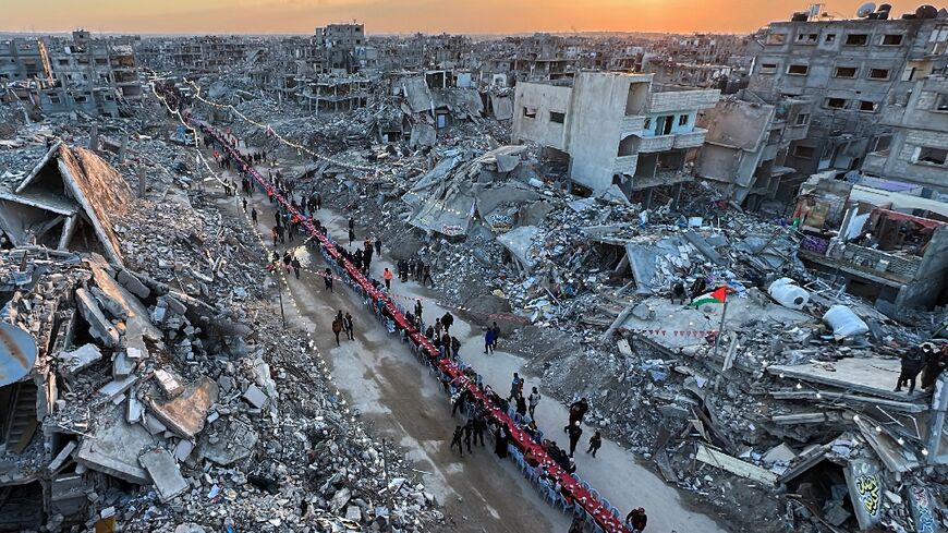 Hundreds sat on a long row of plastic chairs under bunting, Palestinian flags and lights strung between the broken concrete