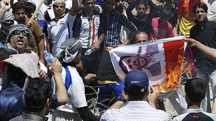 Iraqi Sunni Muslims burn a poster of Iranian President Mahmoud Ahmadinejad during an anti-government demonstration in Falluja, 50 km (31 miles) west of Baghdad April 26, 2013. Tens of thousands of Sunni Muslims poured onto the streets of Ramadi and Falluja in the western province of Anbar following Friday prayers, in protest at the perceived marginalisation of their sect since the U.S.-led invasion overthrew Saddam Hussein and empowered majority Shi'ites through the ballot box. Iraq's delicate ethno-sectari