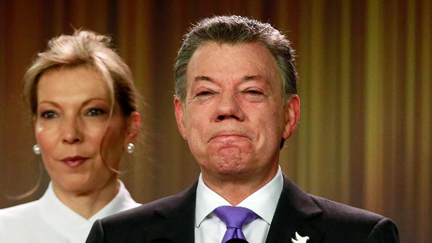Colombia's President Juan Manuel Santos reacts as he addresses the media next to his wife and first lady Maria Clemencia de Santos, after winning the Nobel Peace Prize, at Narino Palace in Bogota, Colombia, October 7, 2016. REUTERS/John Vizcaino     TPX IMAGES OF THE DAY      - RTSRAJC