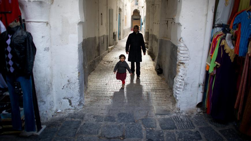 A mother and her child walk in a street of "La Medina" in cental Tunis on January 21, 2011. Tunisia began national mourning Friday for the dozens killed in its revolution, a week after the ouster of veteran ruler Zine El Abidine Ben Ali, as new protests called for the old regime to be destroyed. AFP PHOTO / MARTIN BUREAU        (Photo credit should read MARTIN BUREAU/AFP/Getty Images)