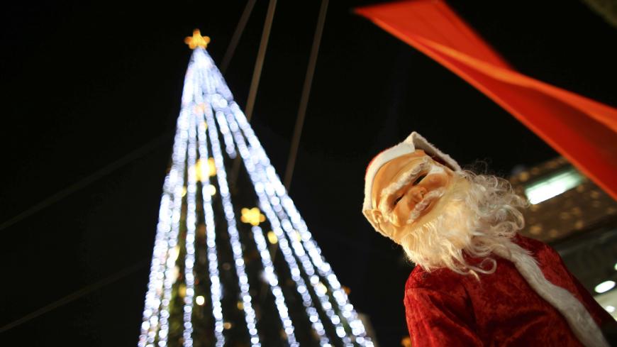 A boy wearing a Santa Claus costume attends a Christmas tree lighting ceremony in the northern town of Nazareth, the town of Jesus' boyhood, December 12, 2012. REUTERS/Ammar Awad (ISRAEL - Tags: RELIGION) - GM1E8CD0CSI01