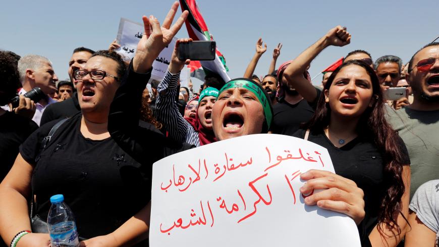 Protestors chant slogans during a demonstration near the Israeli embassy in Amman, Jordan July 28, 2017. The poster reads "Close the terrorist embassy, dignity for the people". REUTERS/Muhammad Hamed - RC1D89B3BBD0