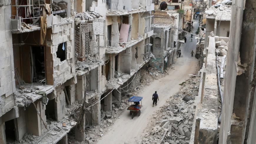 Residents walk near damaged buildings in the rebel held area of Old Aleppo, Syria May 5, 2016. REUTERS/Abdalrhman Ismail/File Photo - RC1FE5D0C050