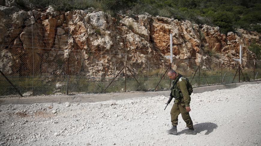 An Israeli soldier walks near the area where the Israeli army is excavating part of a cliff to create an additional barrier along its border with Lebanon, near the community of Shlomi in northern Israel April 6, 2016. Israeli Defence Forces (IDF) Lieutenant-General Eli David, who serves as an engineering officer in a northern division, told Reuters on Wednesday that the army began work on the new barrier by exposing the cliff in January 2015, to help protect communities located close to the Lebanese border 