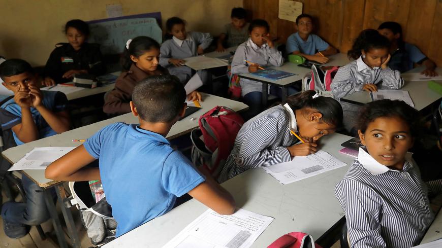 Palestinian Bedouin schoolchildren plattend a course in their classroom on October 21, 2018, in the Palestinian Bedouin village of Khan al-Ahmar, east of Jerusalem, in the occupied West Bank. - Israeli Prime Minister Benjamin Netanyahu has frozen plans to demolish a strategically located Bedouin village in the occupied West Bank that has drawn the world's attention, his office said on October 21. "The intention is to give a chance to the negotiations and the offers we received from different bodies, includi