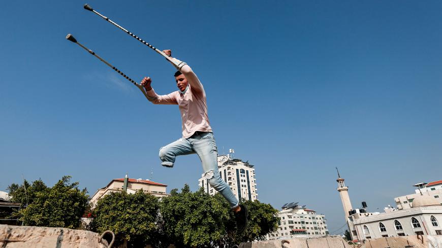 Mohamed Aliwa, a Palestinian youth whose leg was amputated near the knee in 2018 after he was hit by Israeli army fire during protests along the fortified border separating the Gaza Strip from Israel, shows off his parkour skills despite his disability and while on crutches in Gaza City on January 4, 2021. - Parkour, an extreme sport also known as free-running, originated in France in the 1990s. Young people in the Gaza Strip have been practising parkour for years; bounding from ruin to ruin in an enclave p