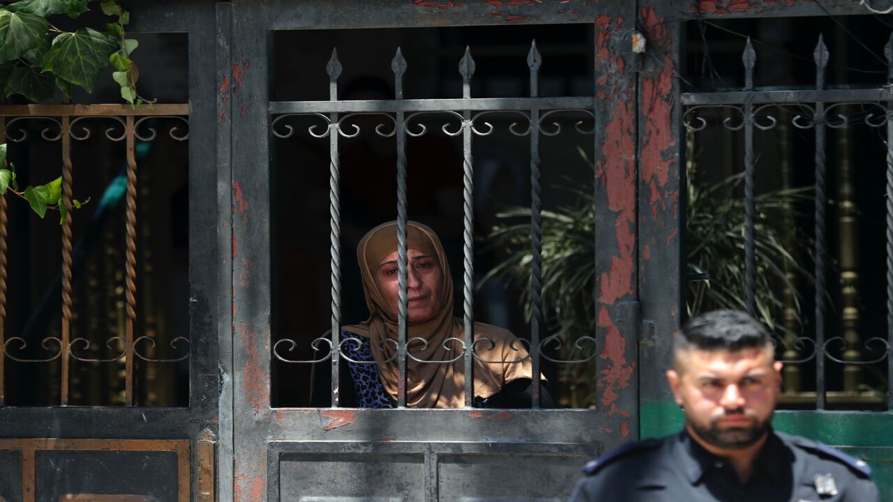 An Israeli policeman stands outside the former house of the Palestinian Siyam family as a member looks from a gate, during their eviction in the Palestinian neighbourhood of Silwan in east Jerusalem near the Old City on July 10, 2019. 