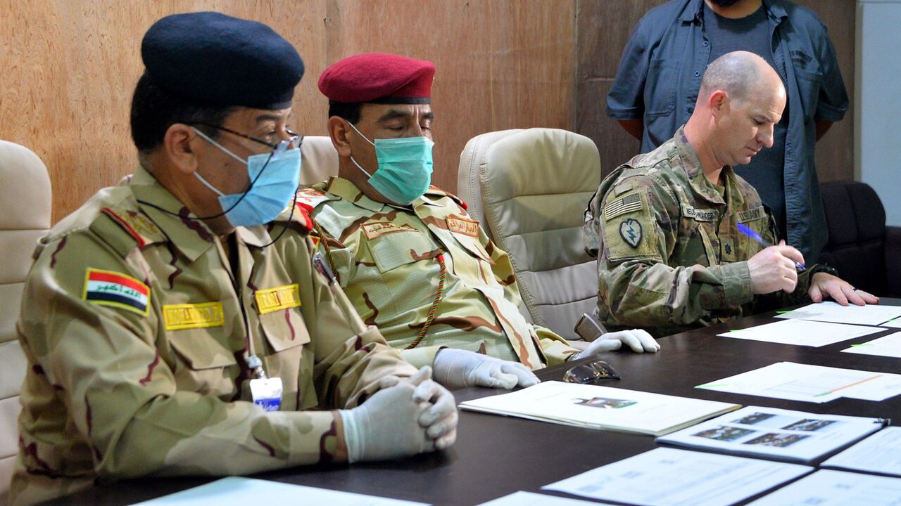 Lt. Col. Jace Neuenschwander signs a document in Mosul