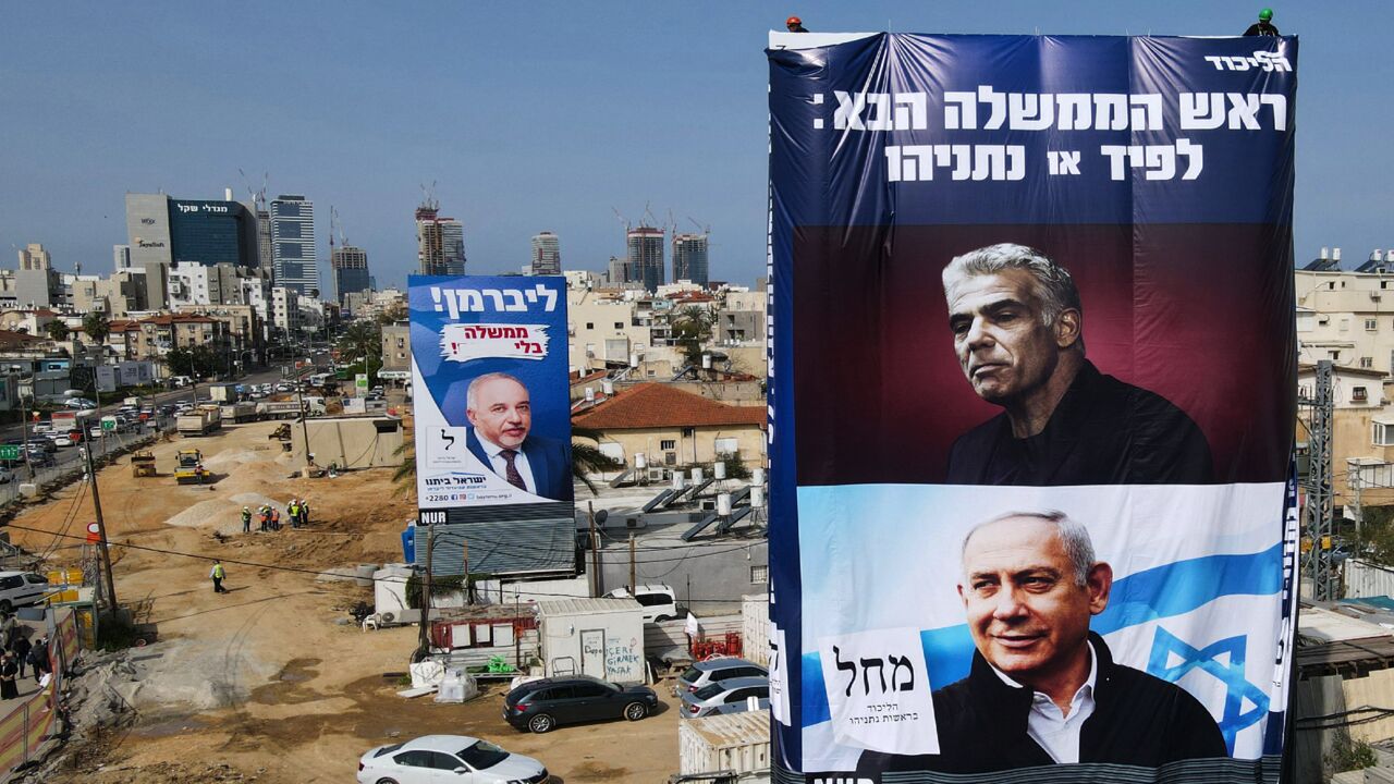 Election campaign posters of Israel's Yisrael Beiteinu party bearing a portrait of its leader Avigdor Liberman (L), the Likud party showing its leader and incumbent Prime Minister Benjamin Netanyahu (bottom-R), and opposition party leader Yair Lapid (top-R) hang on a construction site in the Israeli central city of Bnei Brak, on March 14, 2021. - On March 23, the Netanyahu faces his fourth re-election contest in less than two years, after repeatedly failing to unite a coalition behind him, despite his devot