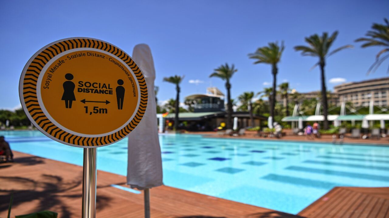 A sign reads "Social distance 1.5m" next to the pool of a hotel on June 19, 2020, at Lara district in Antalya, a popular holiday resort in southern Turkey. The novel coronavirus pandemic has hit Turkey's tourism industry, the backbone of the country's economy.