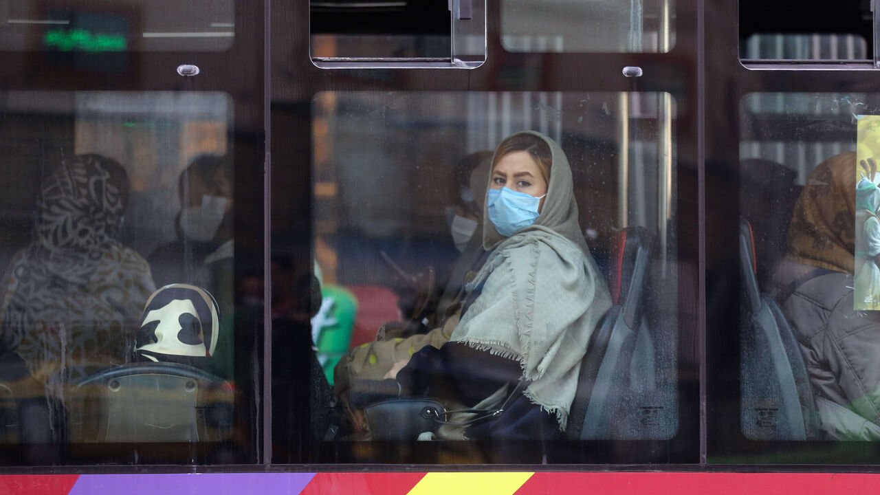 An Iranian woman wearing a protective mask amid the COVID-19 pandemic, sits in a bus in the capital Tehran, on Dec. 30, 2020. 