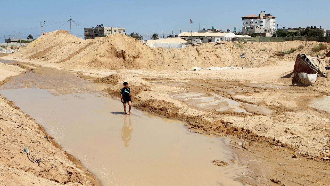 A Palestinian man walks in a pool of water next to the entrance of tunnels, used for smuggling supplies between Egypt and the Gaza Strip, Rafah, Gaza Strip, Sept. 18, 2015.