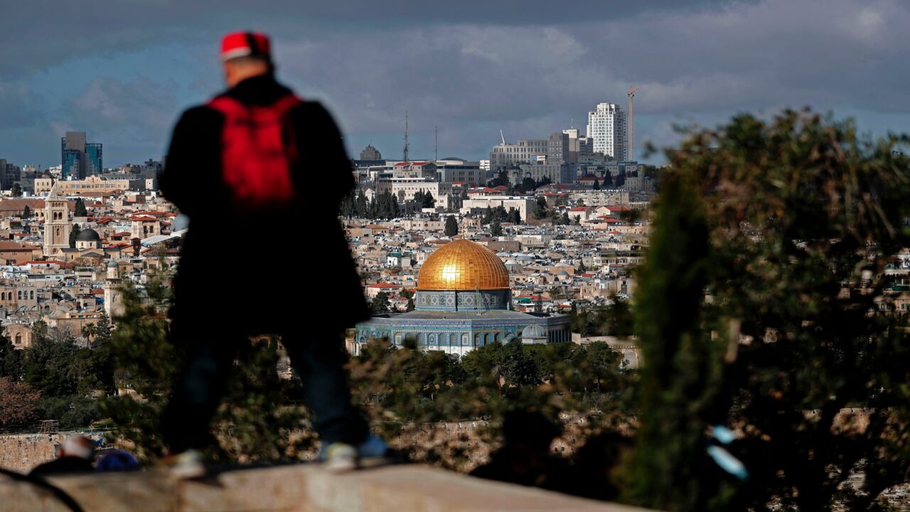 A picture taken from the Mount of Olives on Jan. 20, 2018, shows a Muslim tourist viewing Jerusalem's Old City and the Dome of the Rock. 