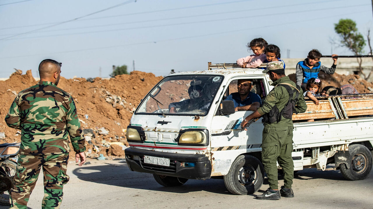 Members of the Syrian Kurdish internal security services known as Asayish and Syrian government forces man a joint checkpoint in the Tayy neighborhood in Qamishli, Syria, April 27, 2021.