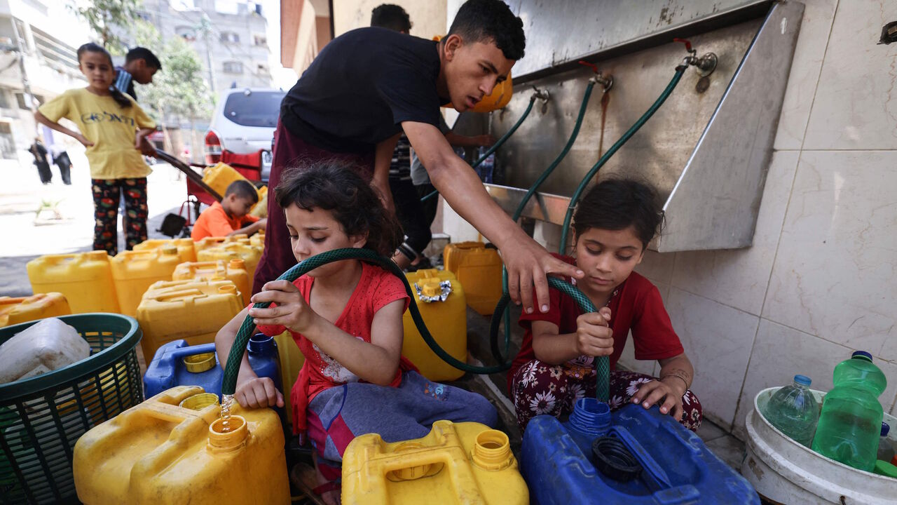 Palestinian children fill up gallons with water in Gaza City on May 20, 2021. 