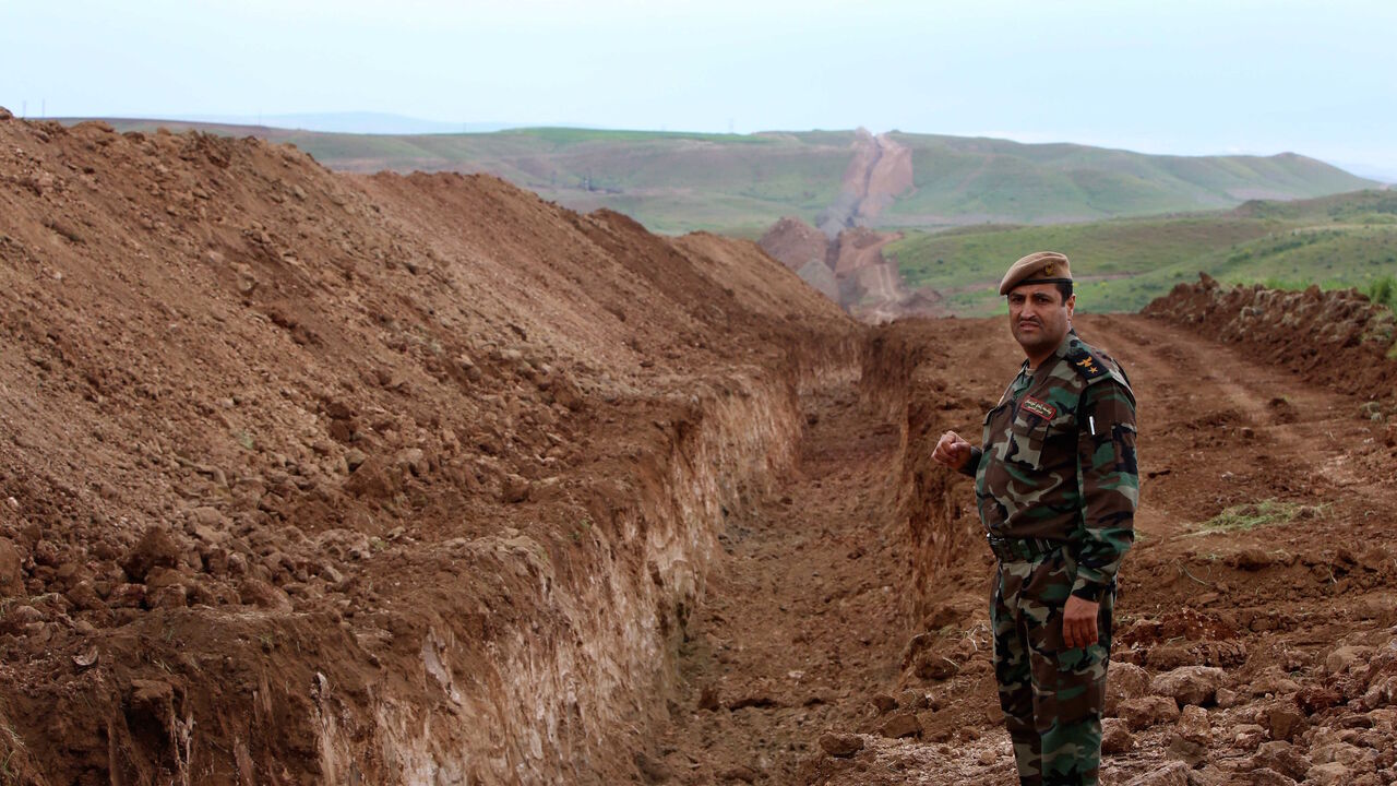 A member of Iraqi security forces looks on during the digging operations to build a trench on the northern Iraqi border with Syria to prevent people from crossing over into Iraq's autonomous Kurdistan region, on April 13, 2014 in Zakho.