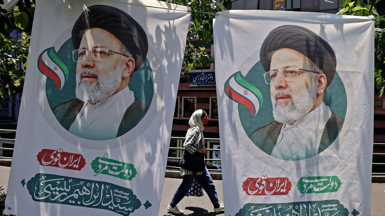 An Iranian woman walks past banners of ultraconservative cleric and presidential candidate Ebrahim Raisi, in Tehran, on June 17, 2021, on the eve of the Islamic republic's presidential election.