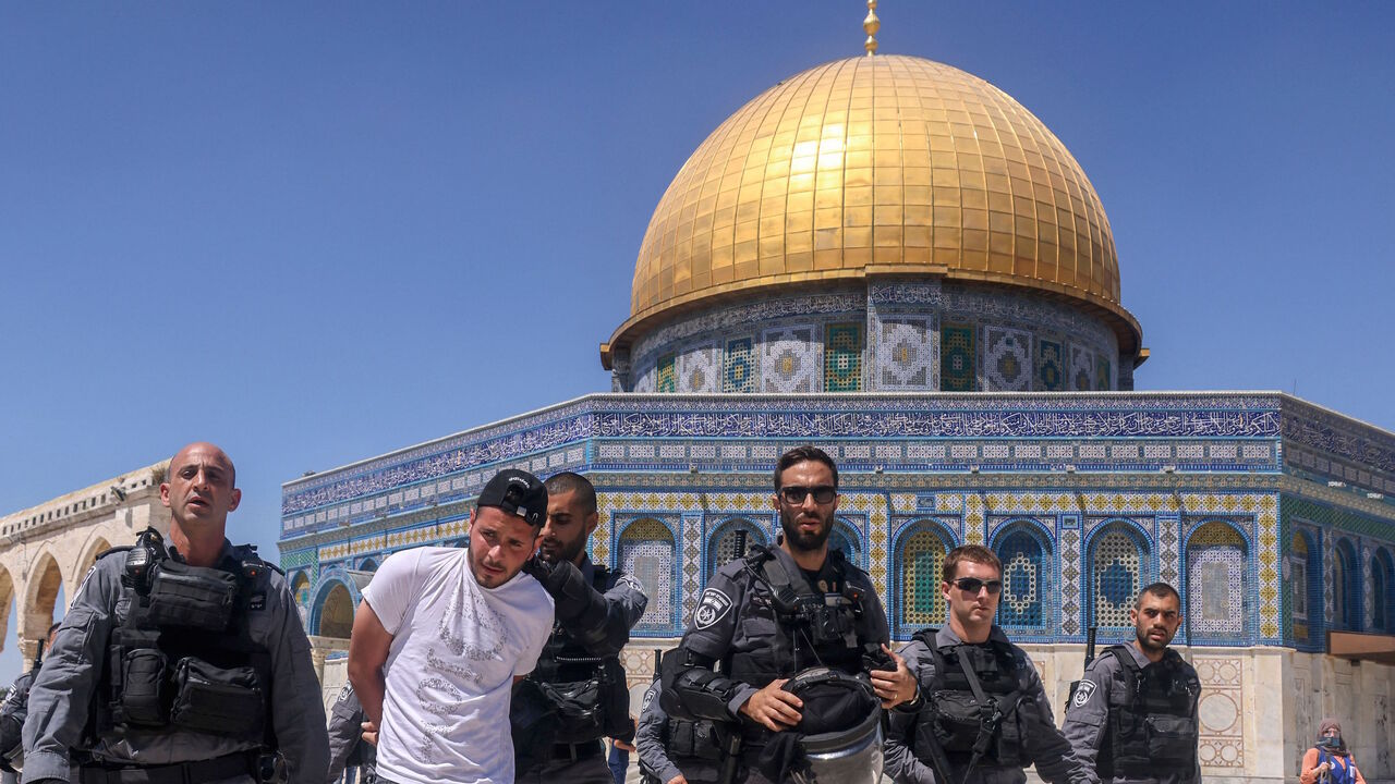 Members of the Israeli security forces detain a Palestinian man in front of the Dome of the Rock mosque following Friday prayers in Jerusalem's Al-Aqsa mosque complex, on June 18, 2021, as Palestinians protested in response to chants by Israeli ultranationalists targeting Islam's Prophet.
