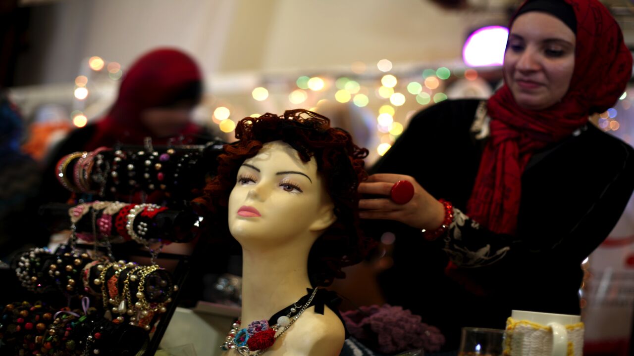 A Palestinian woman displays a mannequin wearing homemade jewelry during an exhibition entitled "Products of our women" in Gaza City on March 16, 2014. 