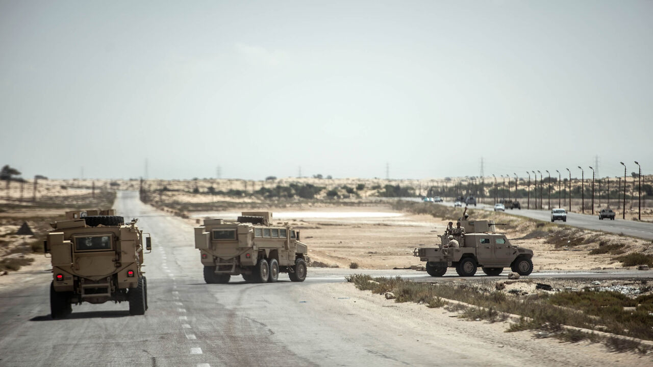 This picture shows Egyptian policemen driving on a road leading to the provincial capital of El-Arish, northern Sinai Peninsula, July 26, 2018.
