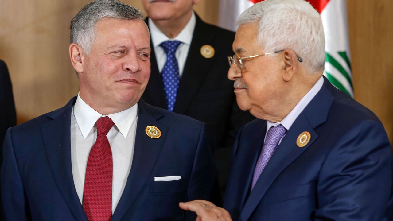 Jordan's King Abdullah II speaks with Palestinian president Mahmoud Abbas while standing for the group family photo with other Arab leaders during the 30th Arab League summit in the Tunisian capital Tunis on March 31, 2019. 