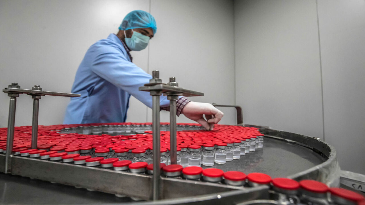 Laboratory workers supervise the production of vials of China's Sinovac vaccine against the coronavirus, produced by the Egyptian company VACSERA, Cairo, Egypt, Sept. 1, 2021.