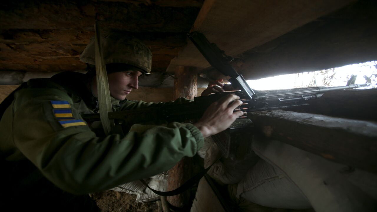 A Ukrainian serviceman loads a machine gun in a dugout on the front line with Russia-backed separatists.