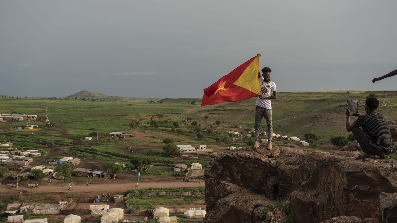 A youth is photographed holding the Tigrayan flag in the Sudanese village of Um Rakuba, home to over 20,000 refugees, on August 18, 2021, in Um Rakuba, Sudan