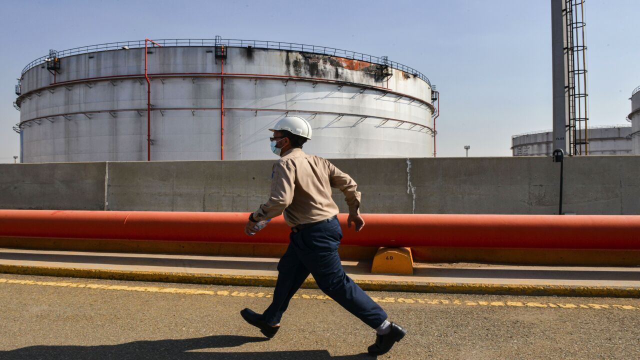 An employee at the Saudi Aramco oil facility walks near a damaged silo at the plant in Saudi Arabia's Red Sea city of Jeddah on Nov. 24, 2020.