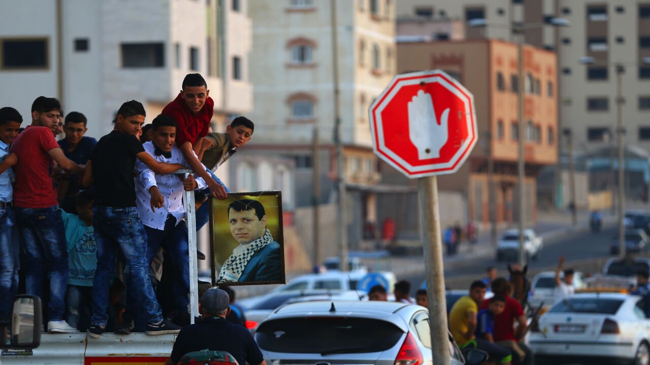 Palestinian youths hold a framed portrait of Mohammed Dahlan during a wedding in Gaza City, June 29, 2017.