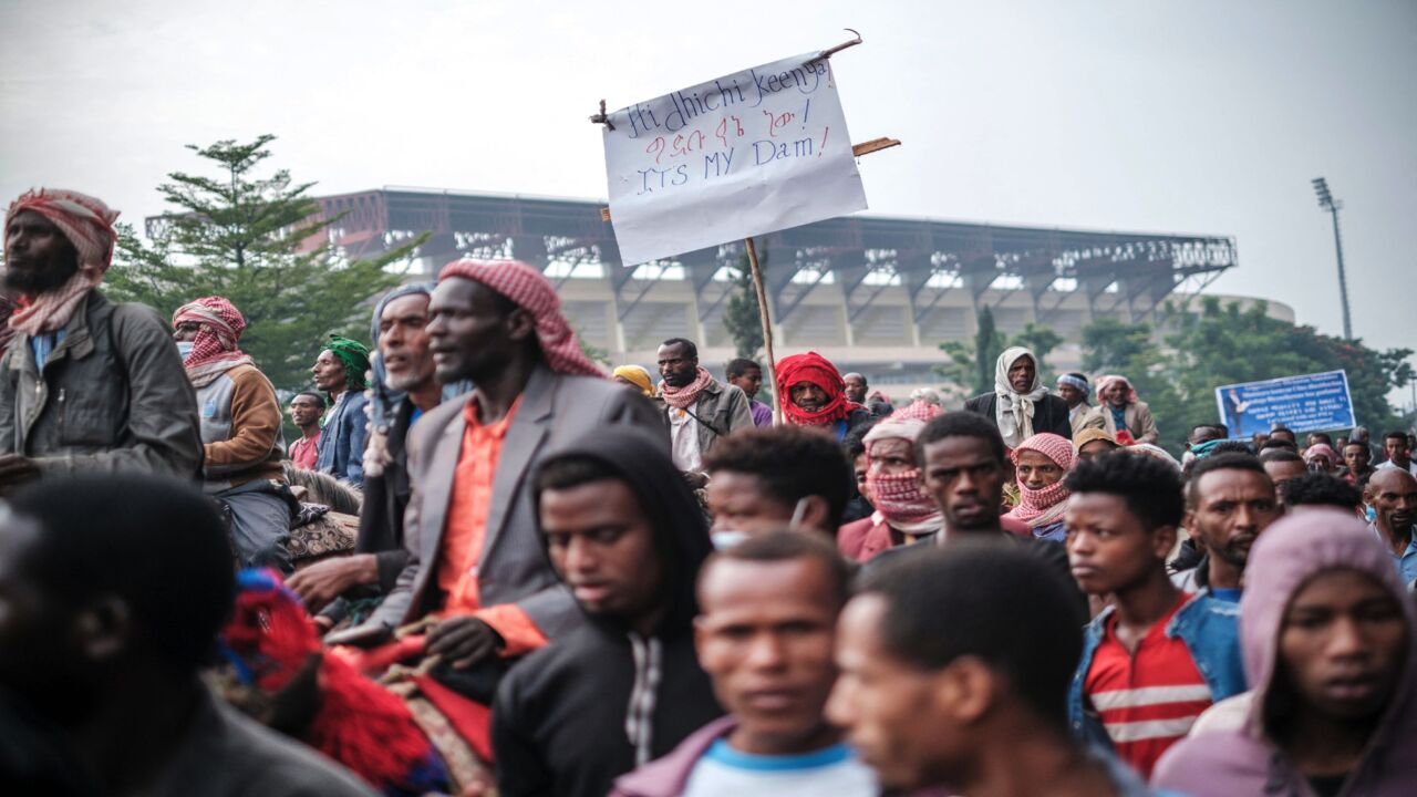A supporter of Ethiopian Prime Minister Abiy Ahmed holds a sign referring to the Grand Ethiopian Renaissance Dam as a crowd waits to enter the stadium in Jimma, June 16, 2021.