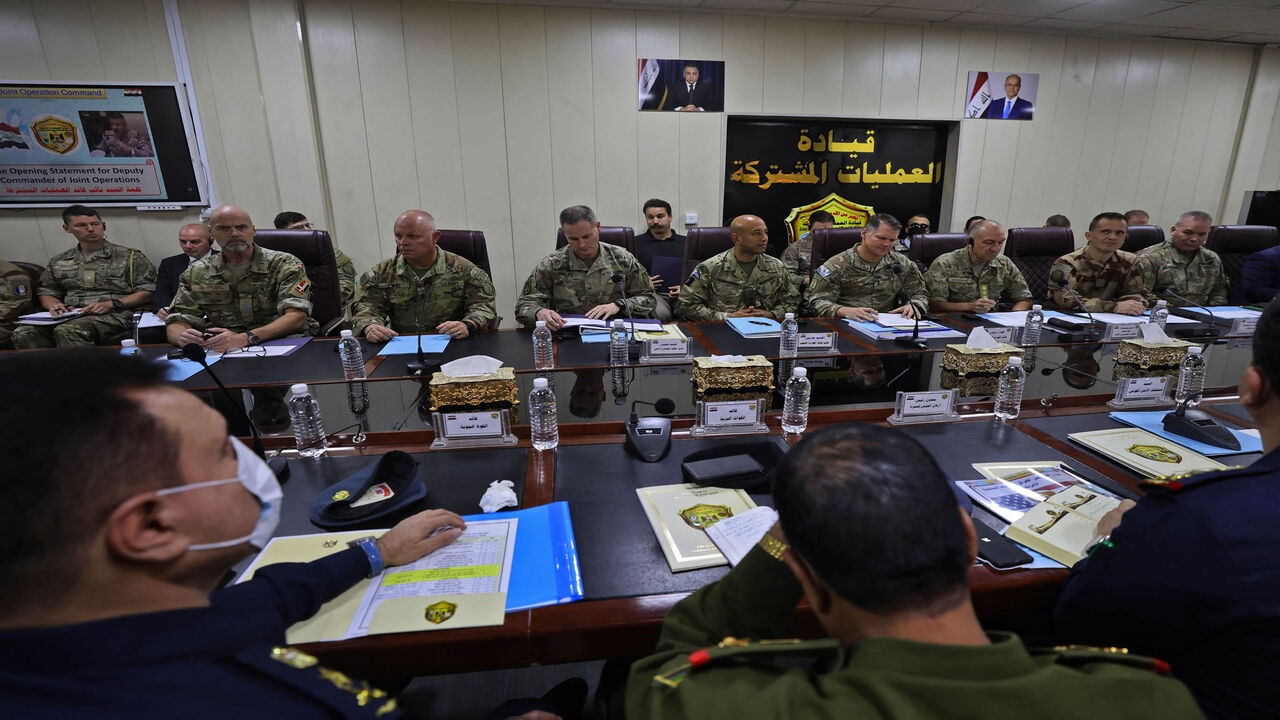 NATO Mission Iraq Commander Lt. Gen. Michael Lollesgaard (3rd-R behind) and Commander of the US-led international coalition against the Islamic State Maj. Gen. John W. Brennan (4th-R behind) attend a meeting of Iraqi and coalition commanders at the Joint Operations Center, Baghdad, Iraq, Dec. 9, 2021.