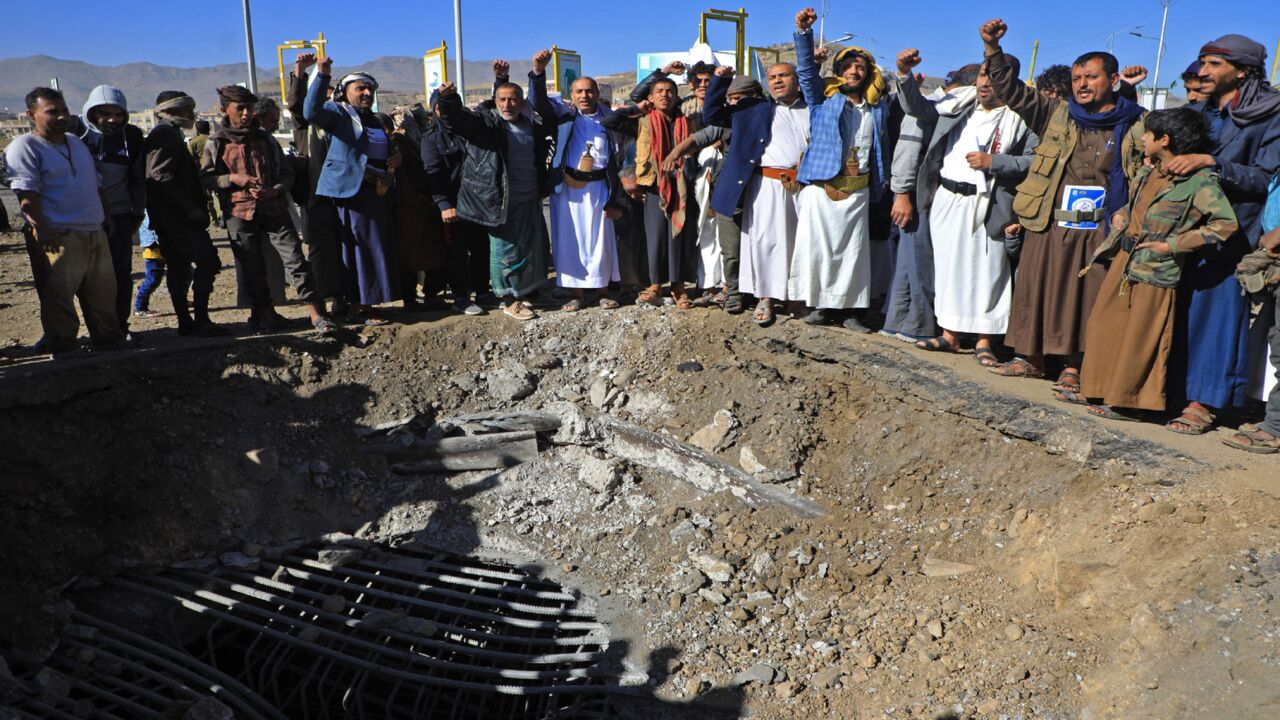 Yemenis inspect a crater following a reported airstrike by the Saudi-led coalition at al-Sabeen square in Sanaa, on Dec. 23, 2021. 