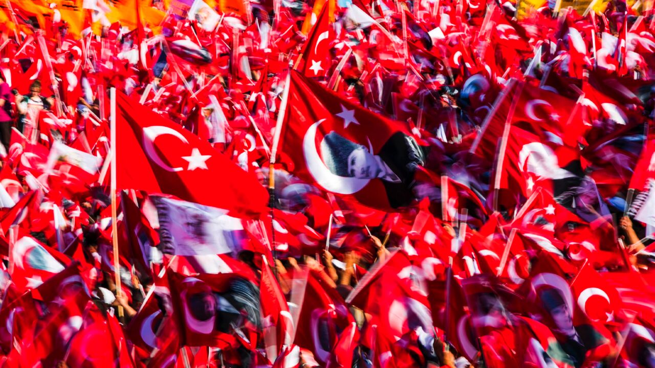 People wave Turkish flags and portraits of modern Turkey's founding father, Mustafa Kemal Ataturk, during a rally organized by main opposition group the Republican People's Party, on July 24, 2016, in Istanbul's Taksim Square. 